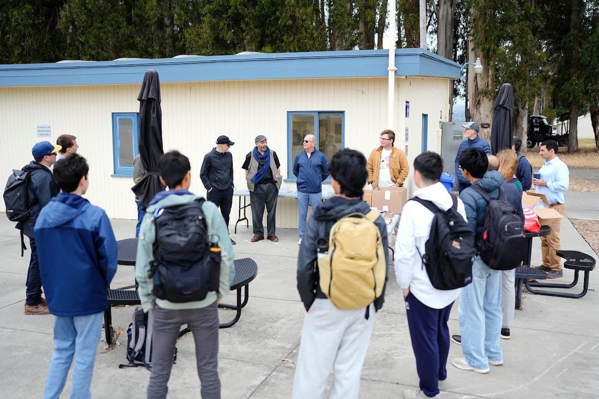 Students and workshop coordinators gather in a semicircle outside a building at Richmond Field Station.