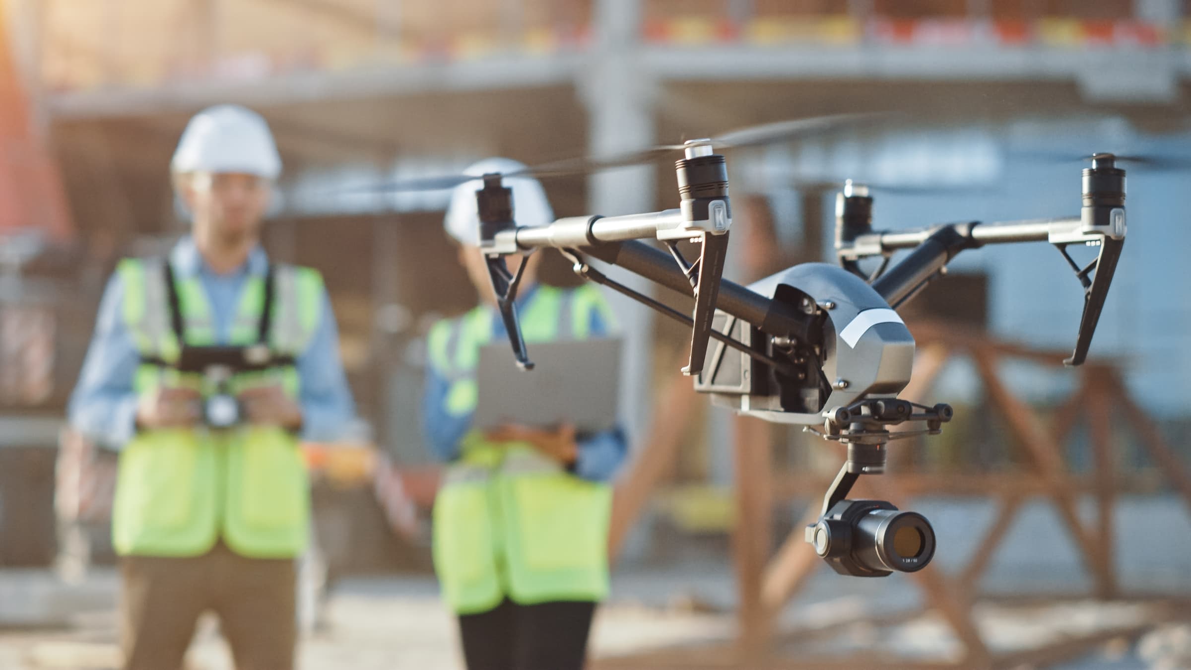 A drone operating beside a flight team in an active field environment.