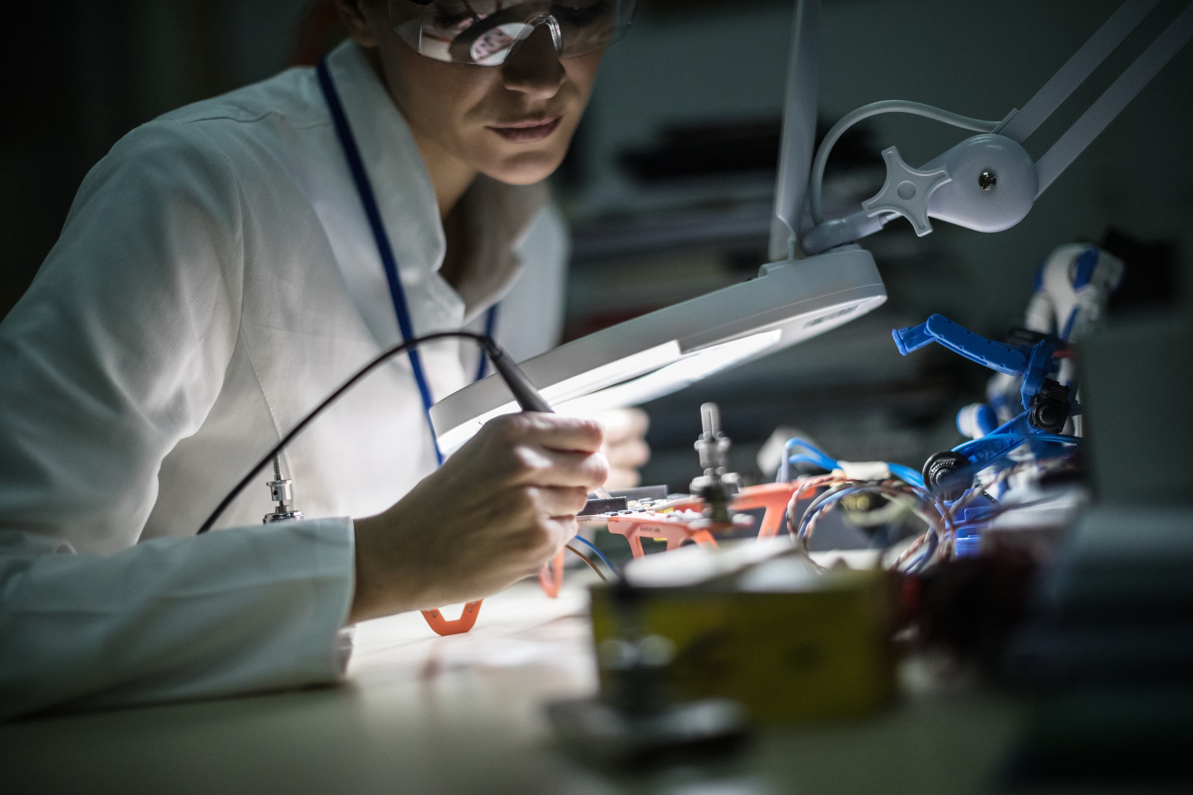 A researcher assembling and inspecting a drone in a laboratory.